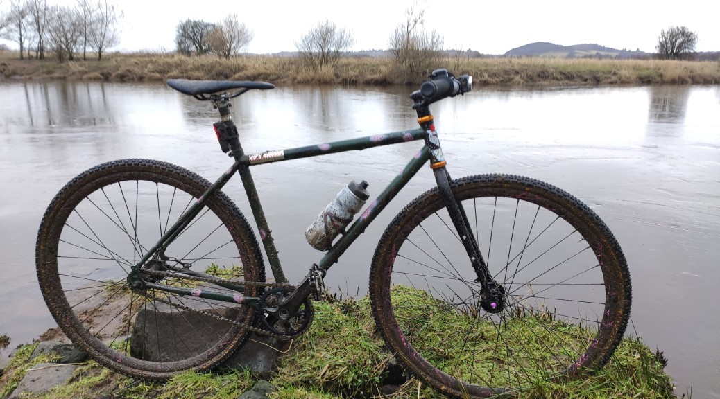 muddy tracklocross bike by river